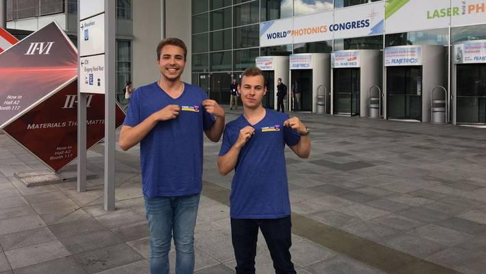 Exkursion Laserworld Die Studierenden posieren vor dem Eingang der Laserworldmesse in München.