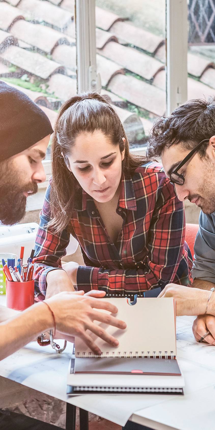 Imagebild Bachelorstudium Tourismus, Studierende sitzen diskutierend an einem Tisch