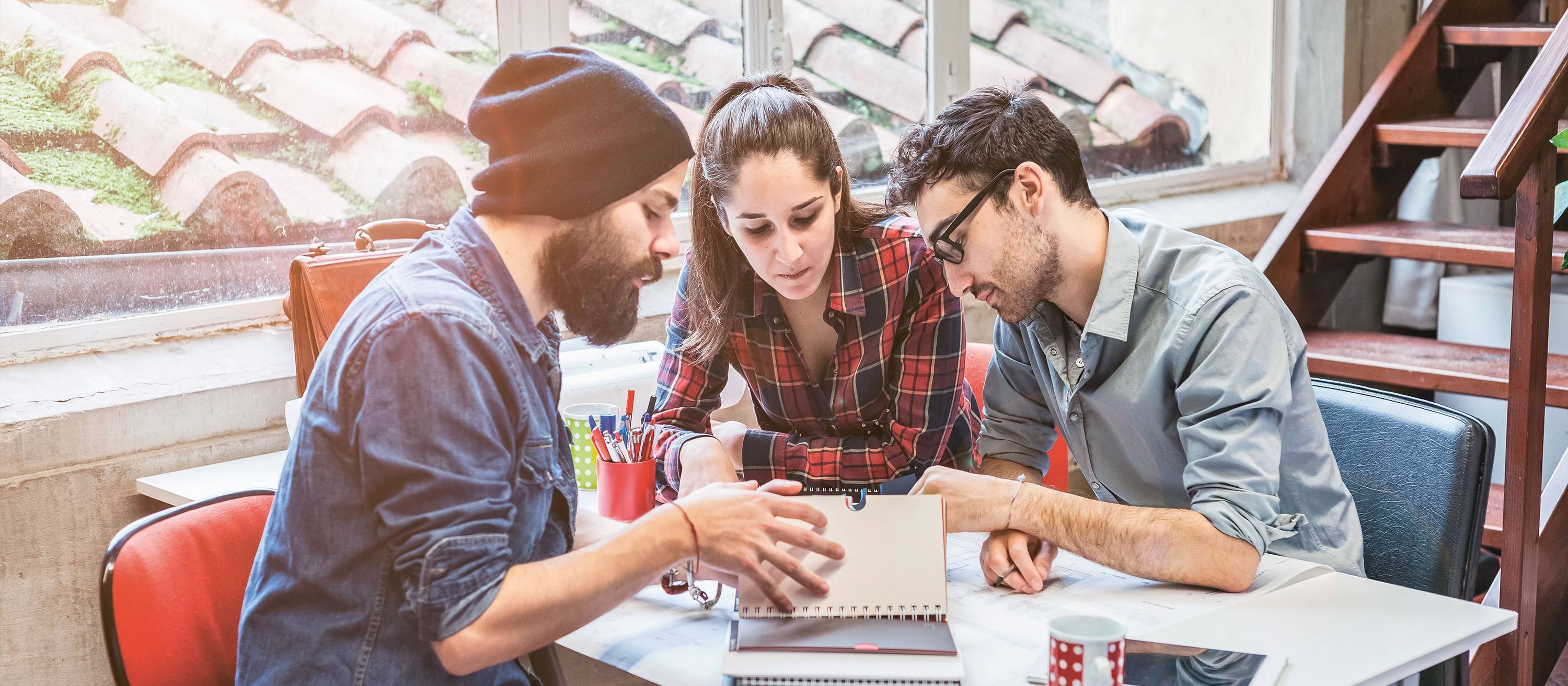 Imagebild Bachelorstudium Tourismus, Studierende sitzen diskutierend an einem Tisch