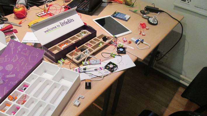 LittleBits Box mit LittleBits aus einem Tisch, die Teilchen sind auf dem Tisch verteilt.