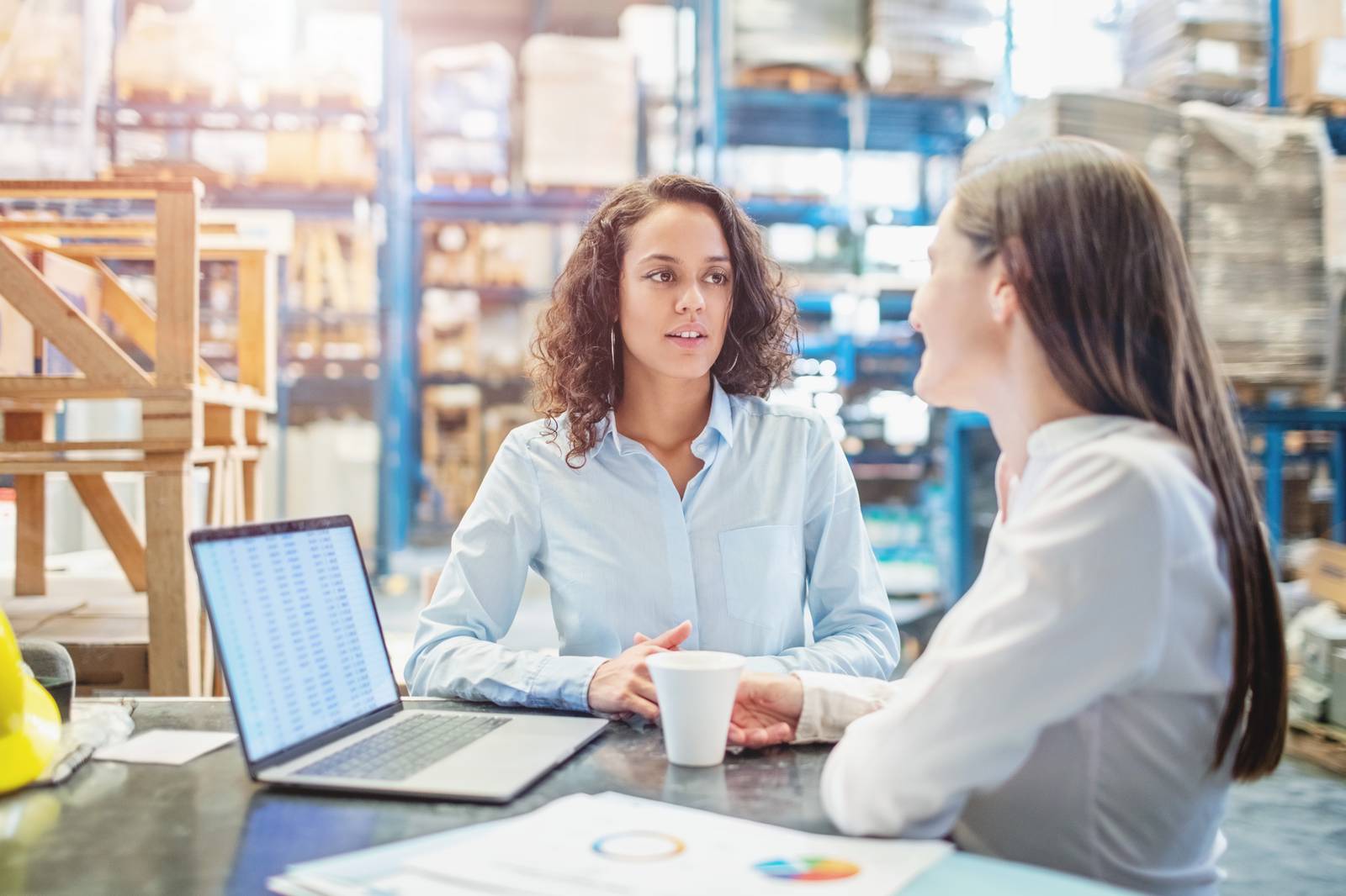 1210182368 Businesswomen discussing over available warehouse stock