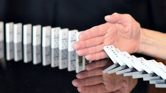 Header Integrity Talk Series Header, Hand hält umfallende Dominosteine auf